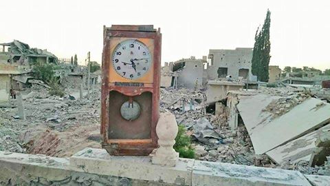 ساعة والدة الكاتب على سطح بيته المدمر في كوباني وفي الخلف تظهر بيوت إخوته التي دمرتها الحرب