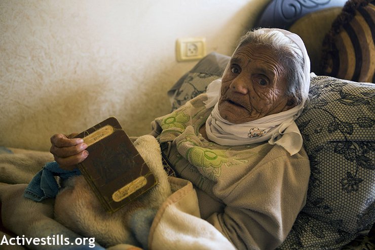 عبسية جعفري التي ناهز عمرها مئة عام لا تزال تحتفظ بجواز سفرها الفلسطيني الصادر في عهد الانتداب البريطاني، قرية الولجة، الضفة الغربية، 23 اكتوبر 2013. تدمرت قرية الولجة الأصلية تماماً في عام 1948 خلال النكبة وأجبر جميع القرويين من السكان على الفرار ليصبحوا لاجئين. (الصورة: آن باك/ Activestills.org) 